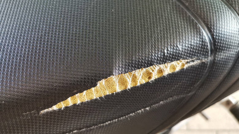 A torn black faux leather couch cushion.