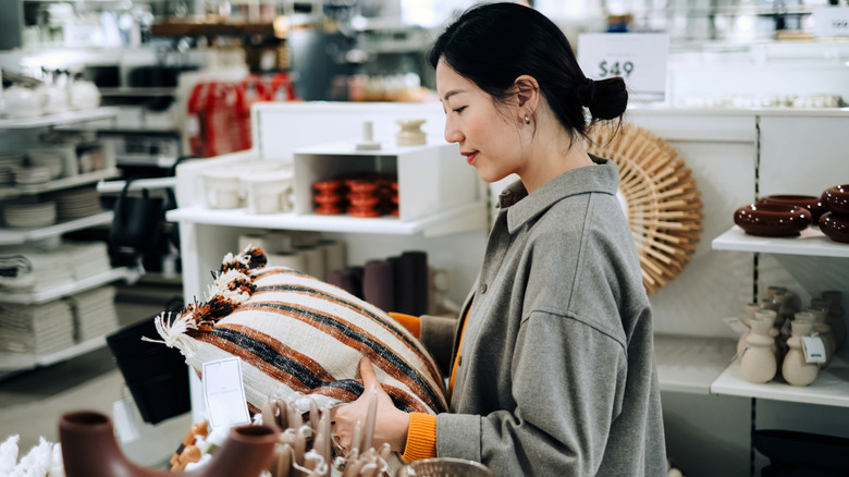 Woman holding a pillow in home decor store