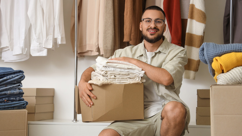 man holding box of clothes