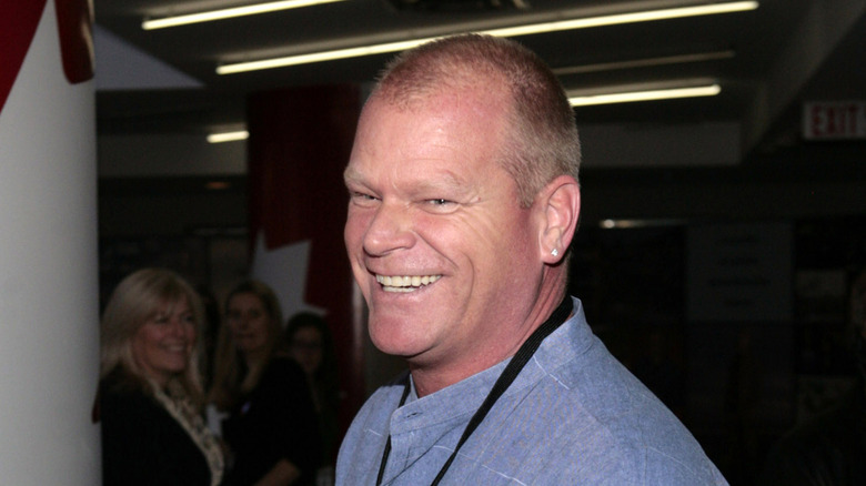 Mike Holmes laughing in a blue shirt.