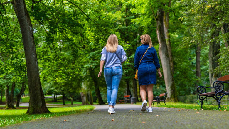 Two women walking through city park