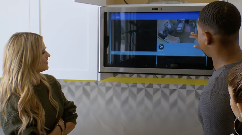 Christina Haack smiling as her client shows her the capabilities of the GE Kitchen Hub smart hood