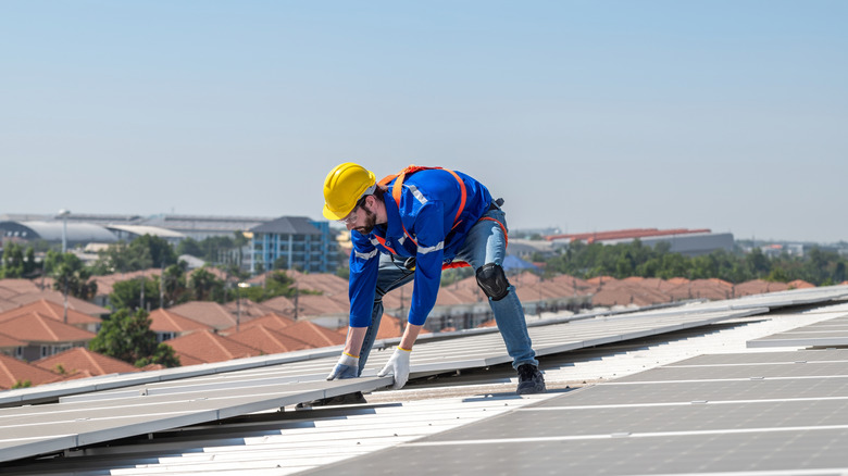 A professional is installing solar panels on the roof of a house