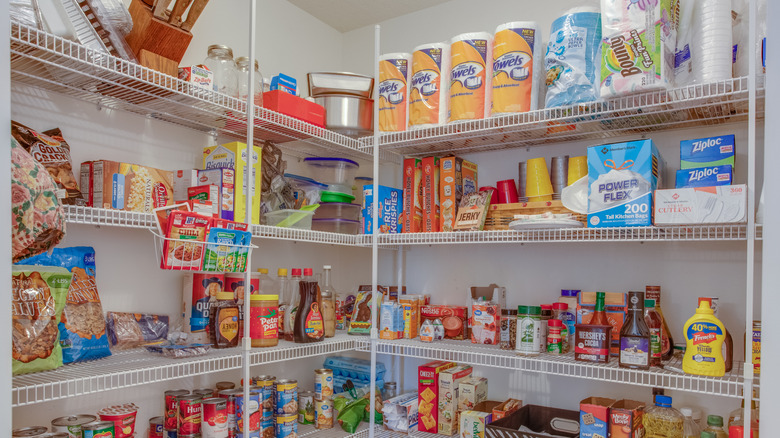 Paper towels arranged on upper shelf in a pantry