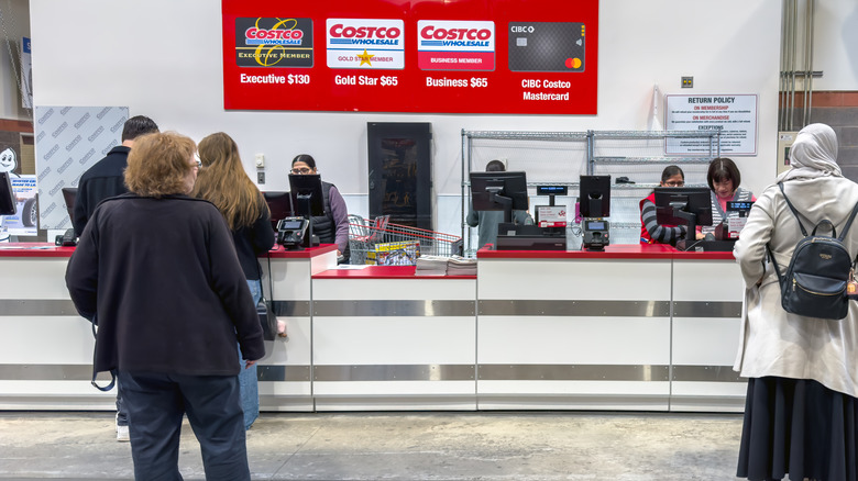 A Costco membership counter where customers are being assisted by employees