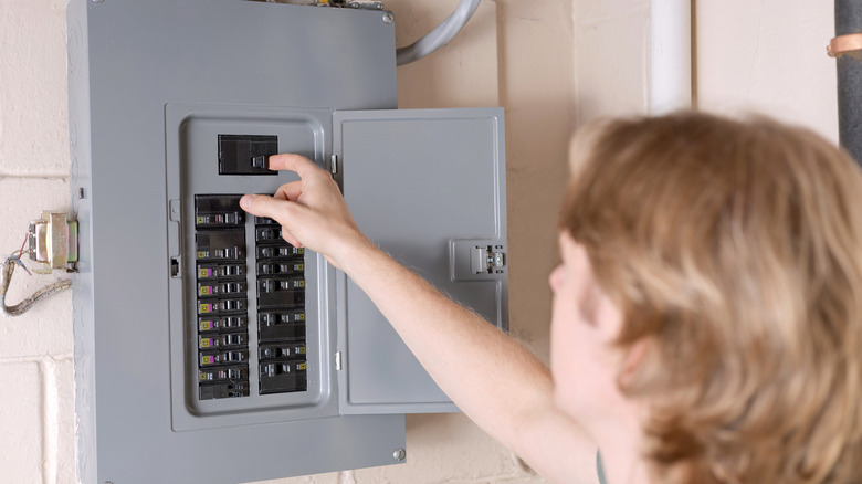 A man is shutting off the main circuit breaker