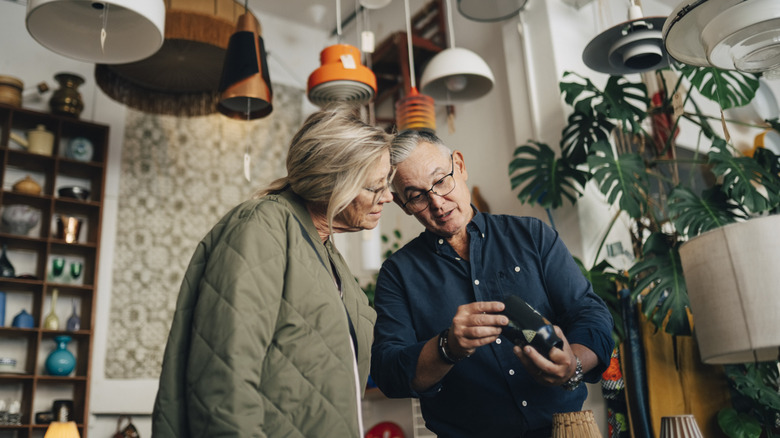 People examining vintage light inside a store