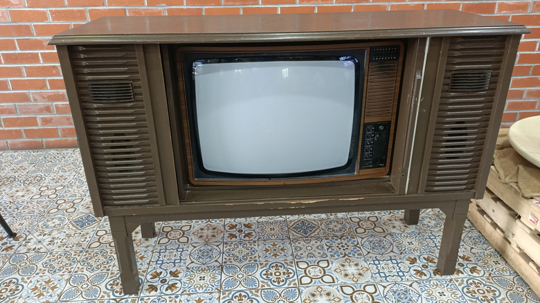 Retro console tv in front of a brick wall