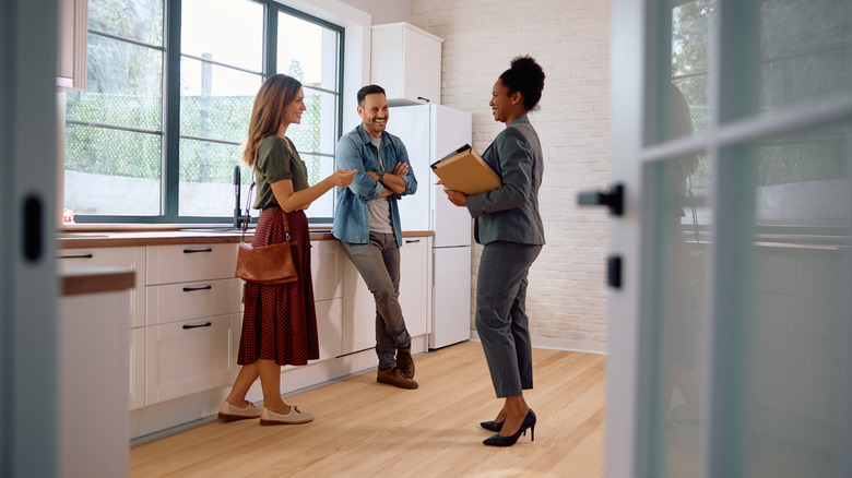 Realtor showing couple a kitchen in house for sale