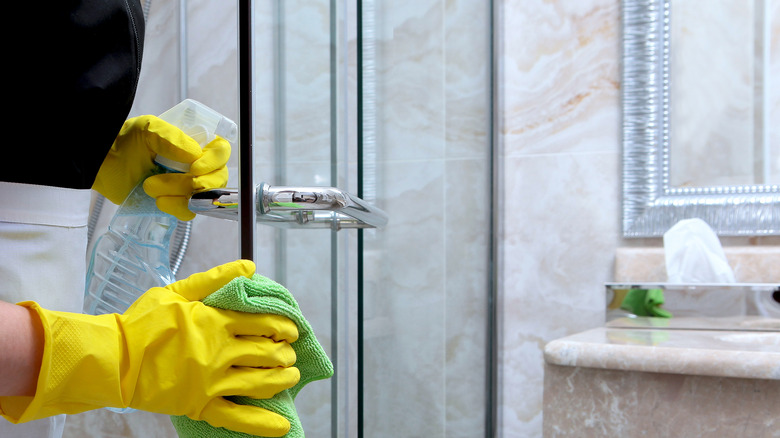 woman cleaning glass shower door