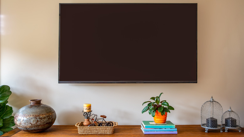 A few decorative items sit below a mounted TV
