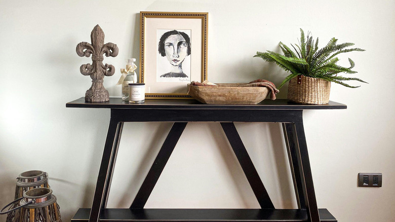 A black entryway table with decorative items