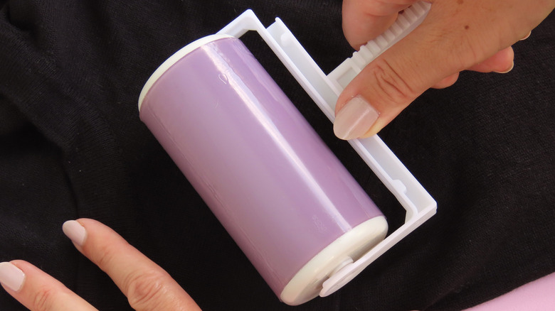 woman using a lint roller on fabric