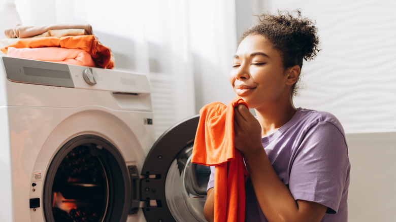 Woman smelling clean clothing fresh out of the drier.