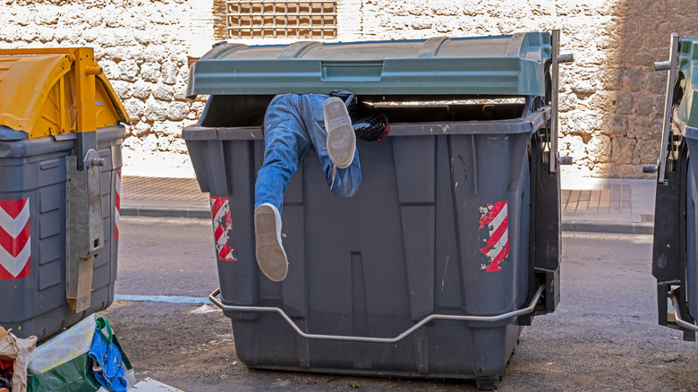 Man diving into dumpster