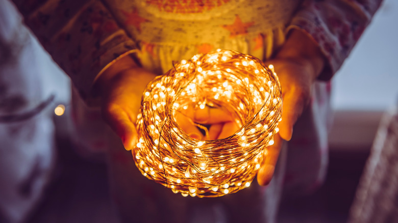 hands holding LED string lights