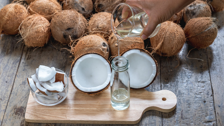 Someone pouring coconut oil into glass jar