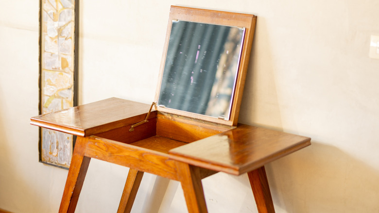 midcentury modern vanity with simple lines, top that opens to show mirror and storage inside the table