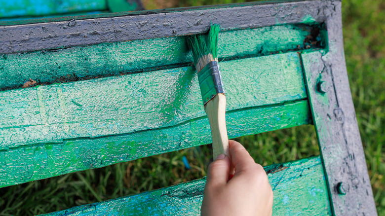 Person painting outdoor furniture