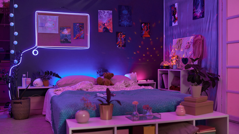 A bedroom at night decorated in shades of pink and purple