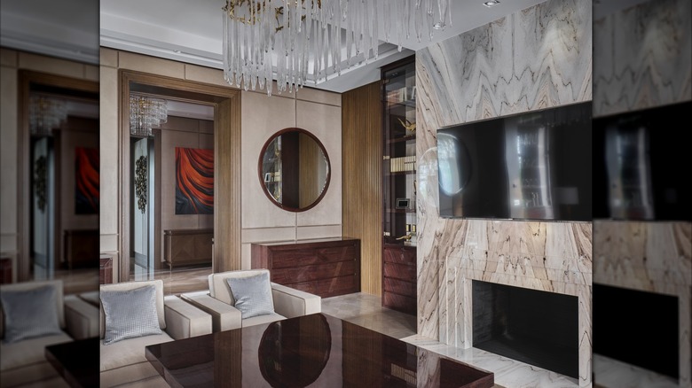 Living room interior with Art Deco details, elegant chandelier, marble accent wall and sophisticated statement pieces