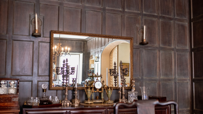 Console table with a mirror and candelabra candle sticks, golden pieces