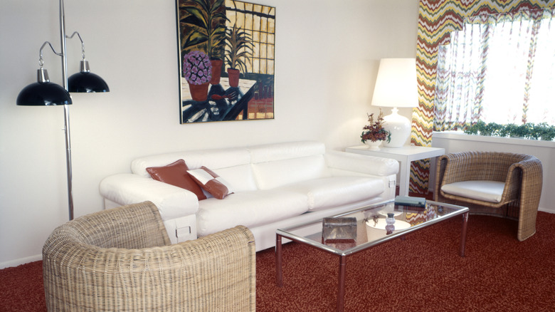 '80s interiors with floor and table lighting, red carpet, and white sofa
