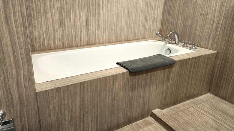 A built-in bathtub with wood paneling