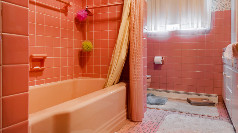 A pink midcentury bathroom with bathtub