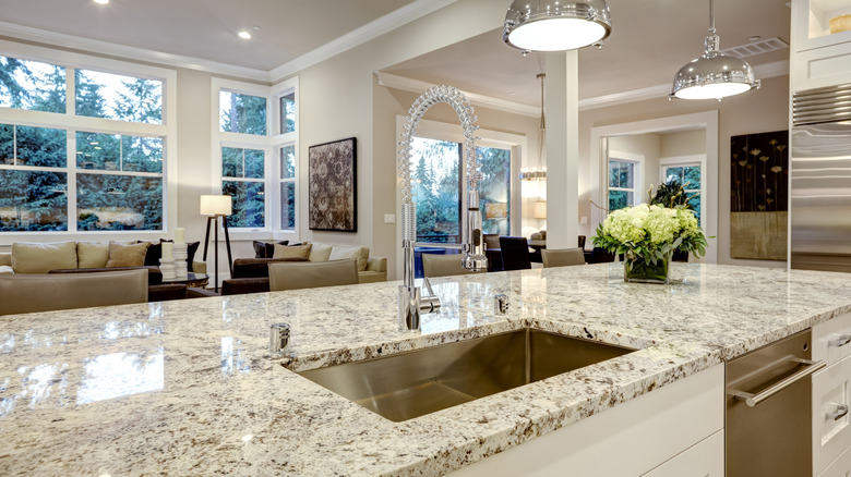 A large white kitchen features speckled granite countertops
