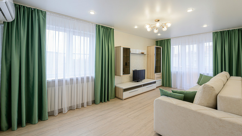 A beige living room with green curtains