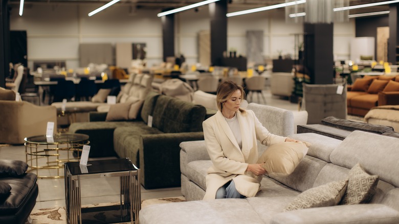 Woman sitting on couch in furniture store