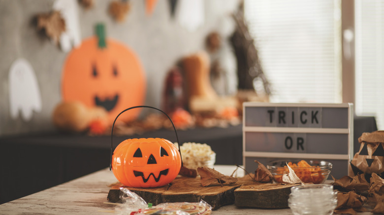 kitschy Halloween decor and a plastic pumpkin on modern table