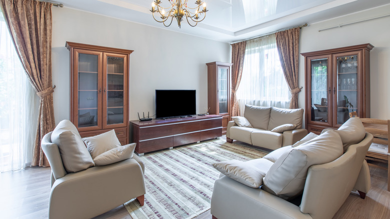 dated living room with matching loveseats and armchair