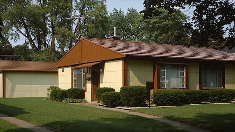 A brown and light yellow Lustron home