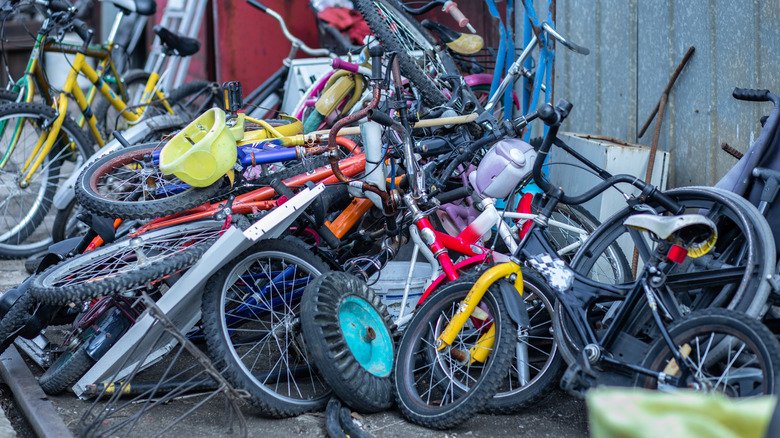 A cluttered pile of bikes outside
