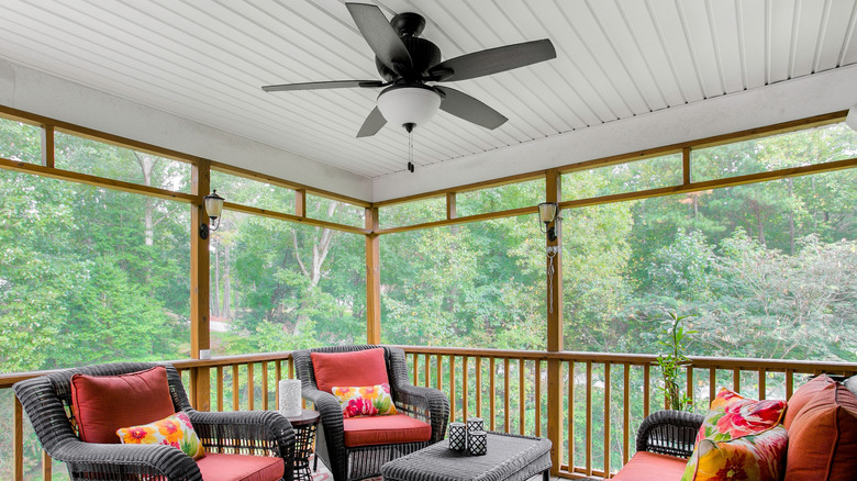 patio with outdoor ceiling fan with red and black furniture