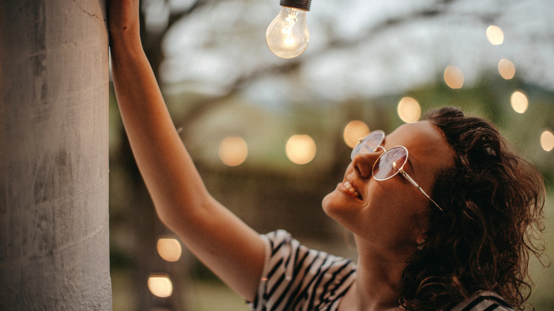 woman enjoying backyard string lights