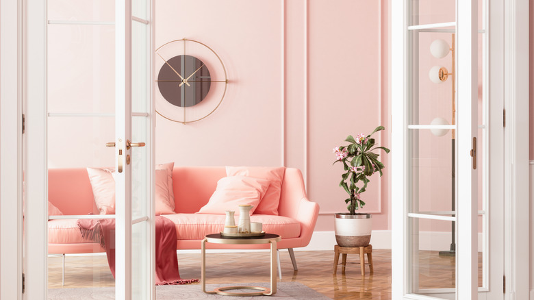 living room with pink walls and a pink couch