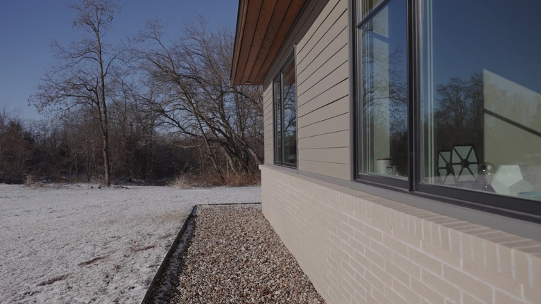 a rock bed, brick veneer, and two-feet over hang means this house doesn't need gutters