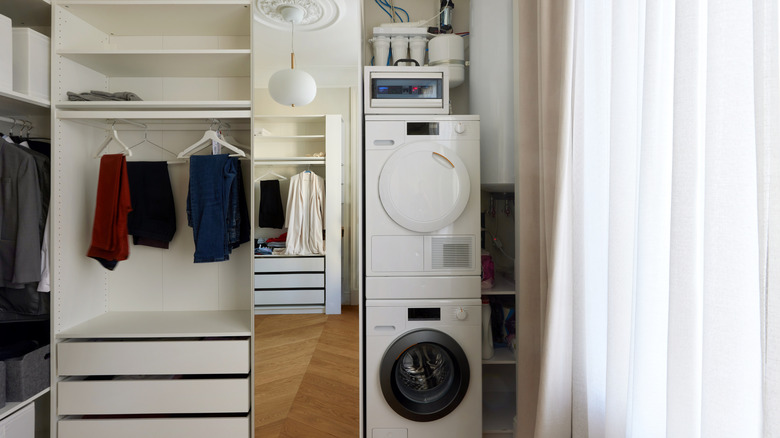 Washer and dryer tucked in the corner of a room near a closet