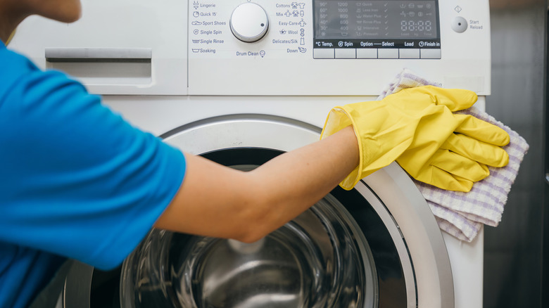 Person wiping the outside of a washing machine