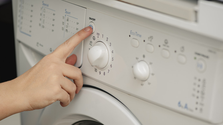 Person turning on a washing machine