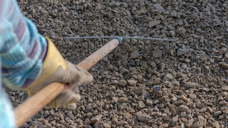 A person raking gravel