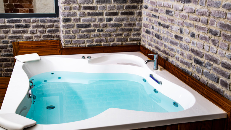 jacuzzi surrounded by brick wall