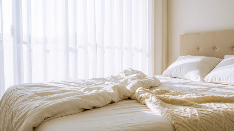 Bed with comforter and decorative throw