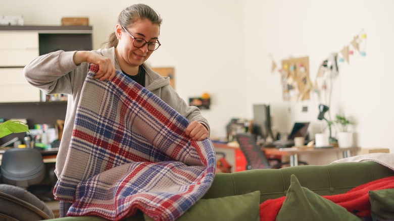 Woman folding plaid blanket