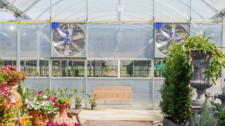 Ventilation fans on a greenhouse with a garden in front