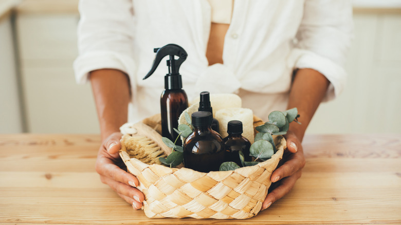 woman holing wicker baskets with cleaning products and tools