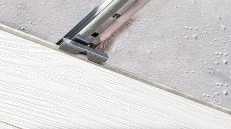 Easy Up track and clip system holding white plank to cover popcorn ceiling